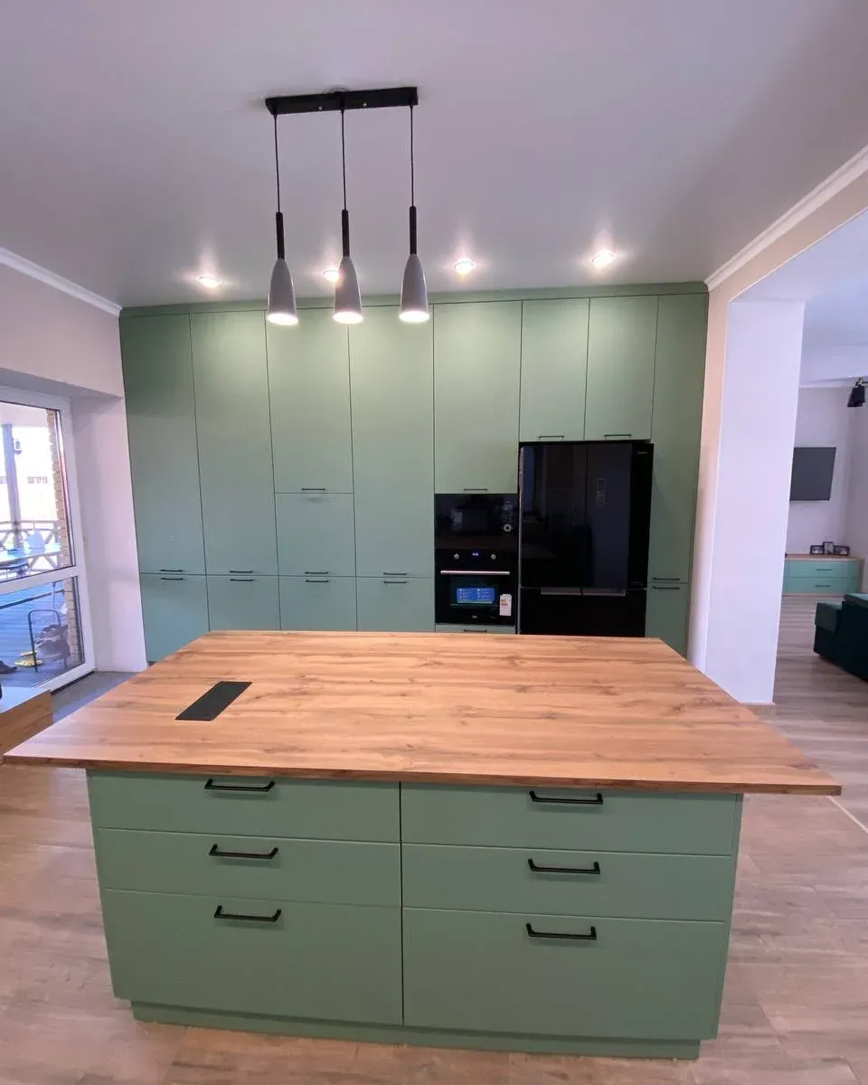 Sage green kitchen with wood-topped island — Pinner, London