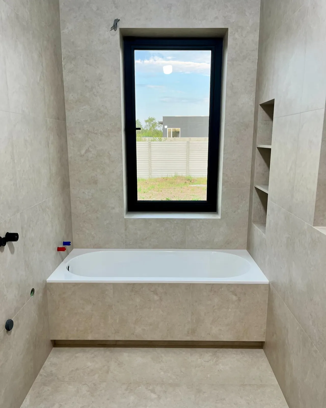 Travertine bathroom with panelled bath — Welling, London