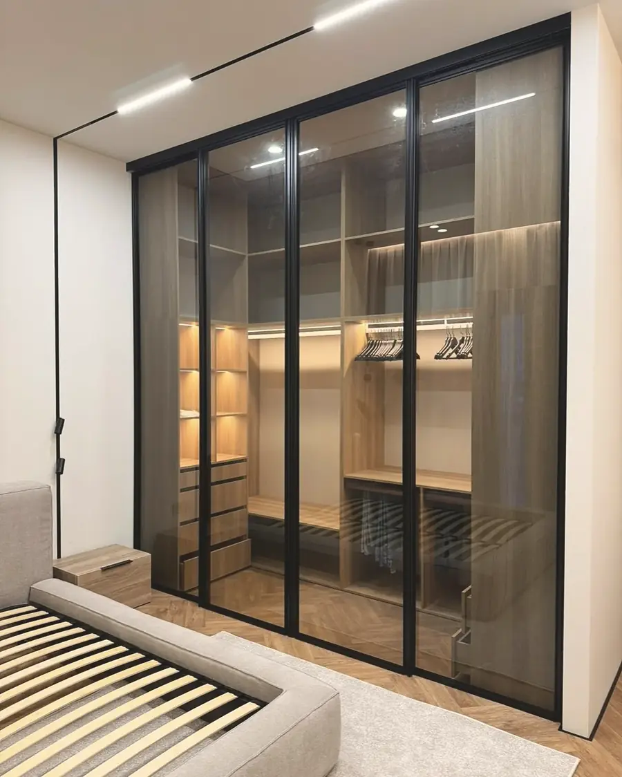 Oak walk-in behind tinted glass sliders — London