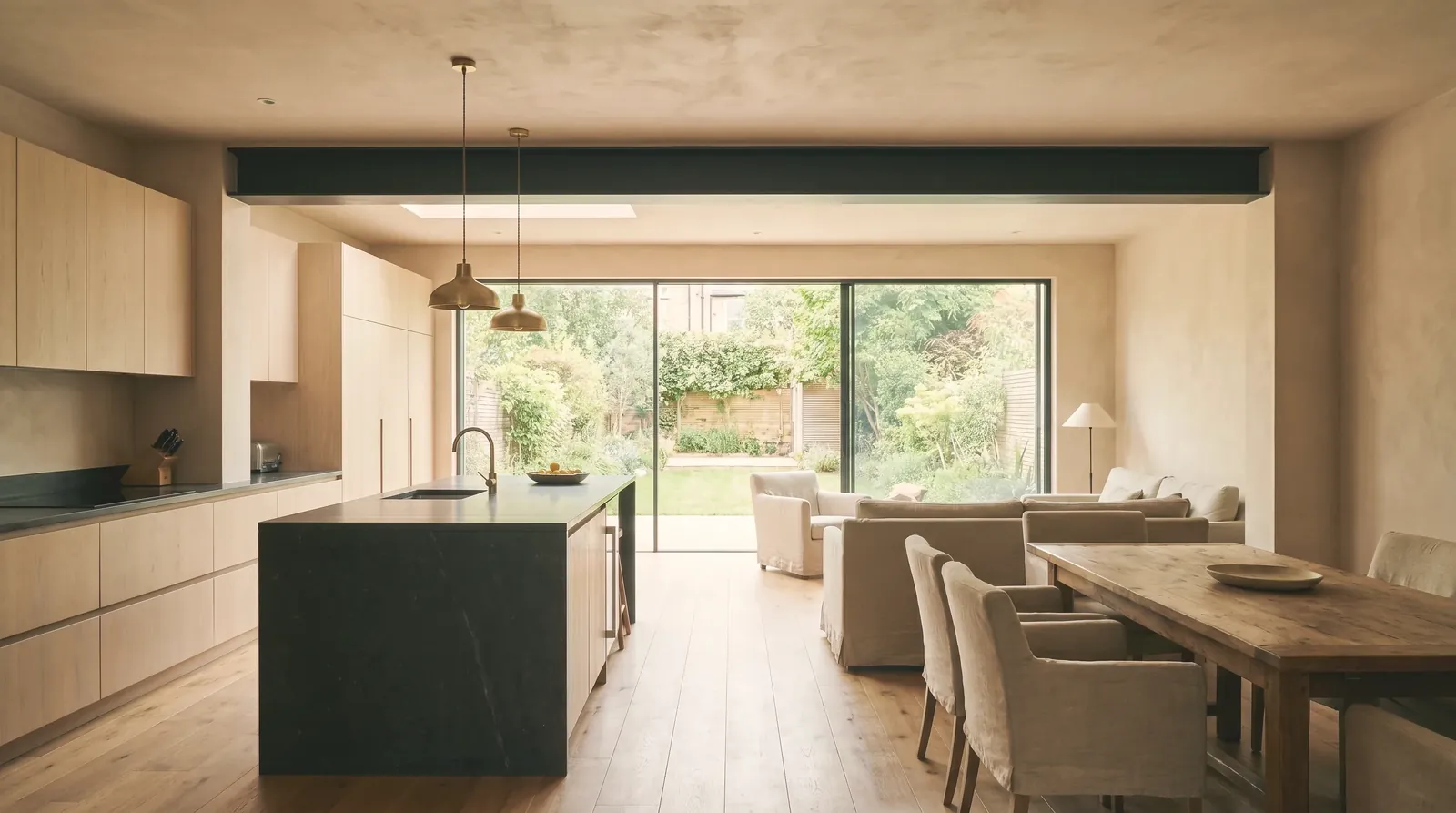 Open-plan London kitchen with an island, fitted units and a steel-beam knock-through opening into the rear reception room.